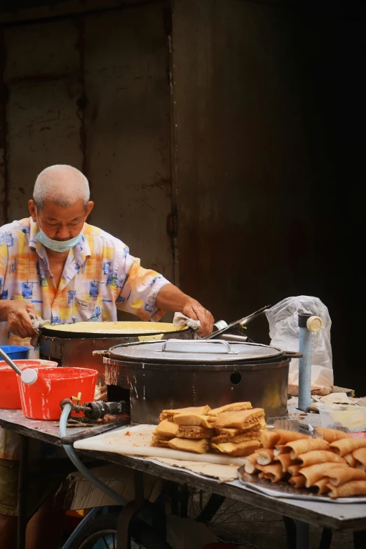 a man is sitting at a table making food