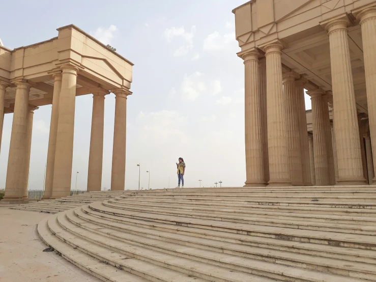 a man is standing near two stone pillars