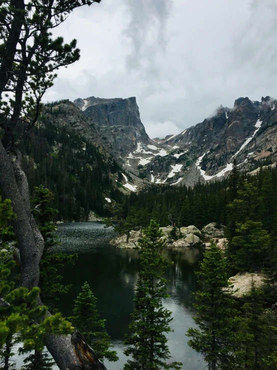 the mountains have snow on them and a lake