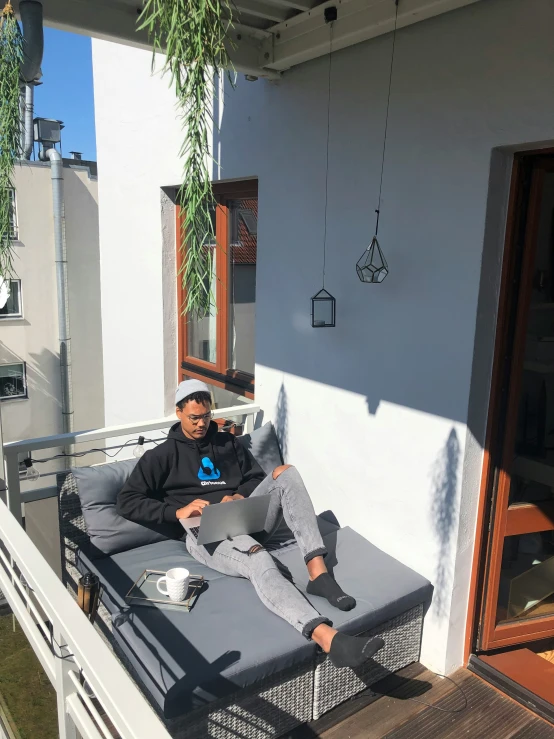 a young man is relaxing on the balcony