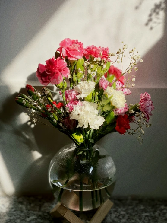 the vase with flowers is on display on a marble base