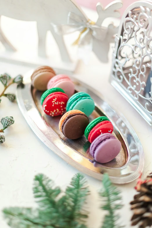 there are several different colored cookies on the dish