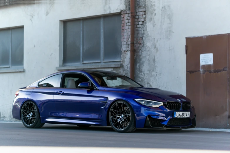 this is a blue sports car parked in front of a building