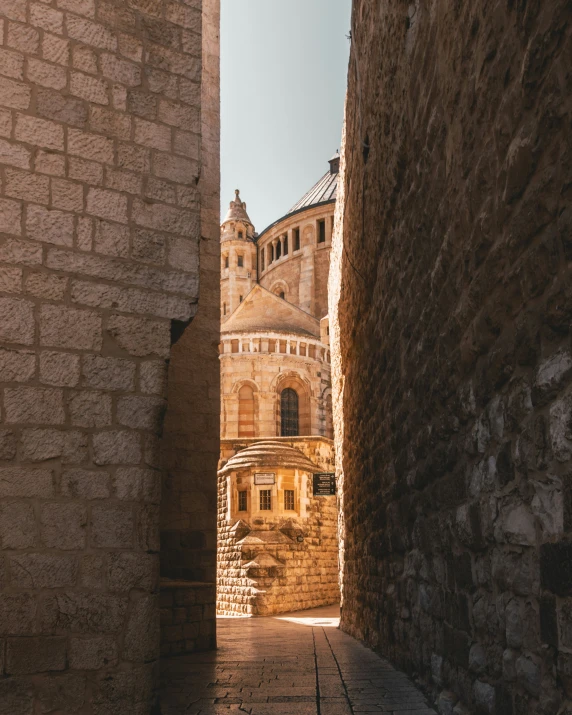 narrow alley way between brick buildings with a clock on top