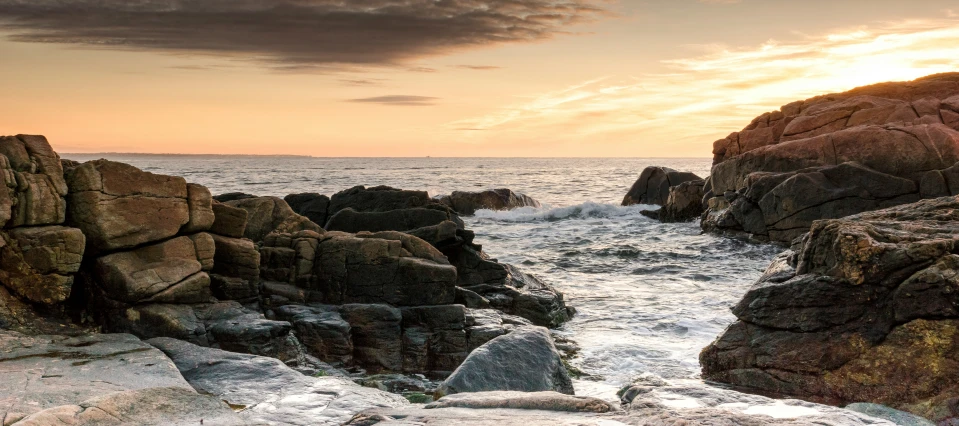 a rocky shoreline with crashing waves, and rocks