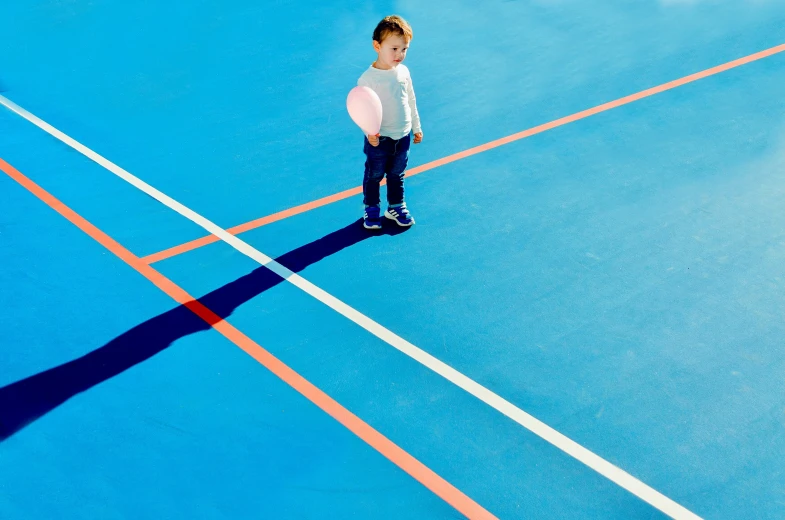 a little girl is holding an orange frisbee