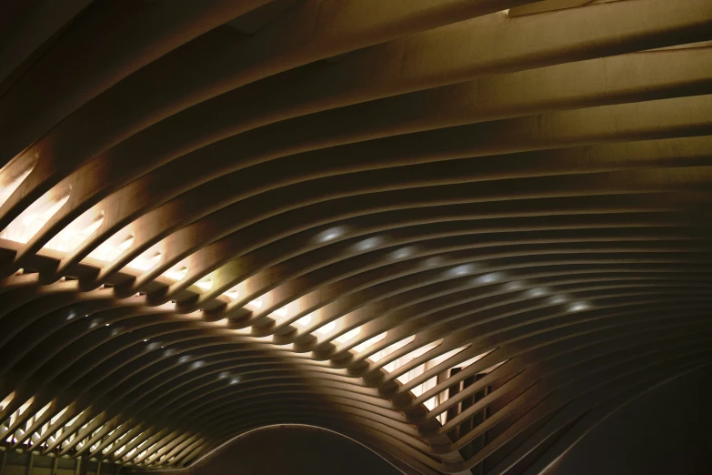 the ceiling of an indoor building with a clock on it