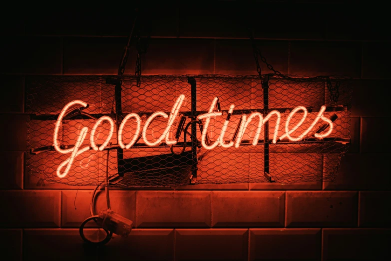 a neon sign reading goodbye in front of a brick wall