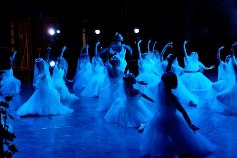 the woman in white dress are posing for a group po