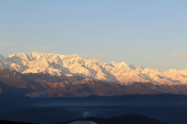 the majestic snow - capped mountains glow in the sunset