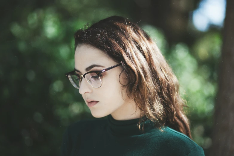 a woman wearing glasses is staring into the distance