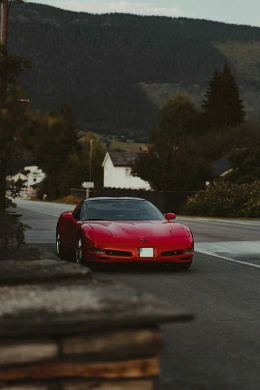 a car sitting in the road between some houses