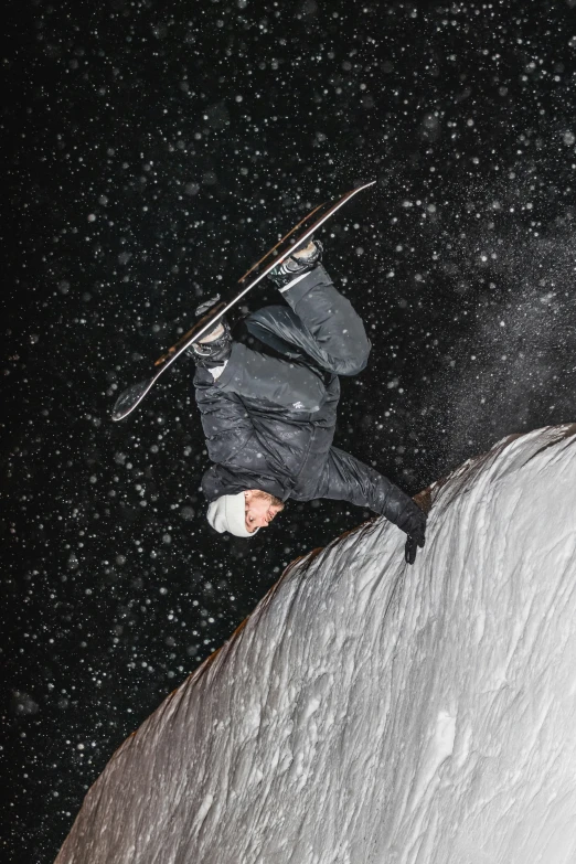 snow boarder in mid air on snowy night