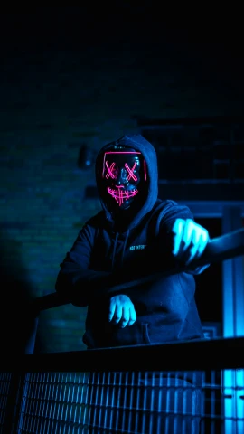 a man in a neon mask stands on a rail