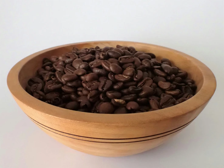 a wooden bowl full of brown beans