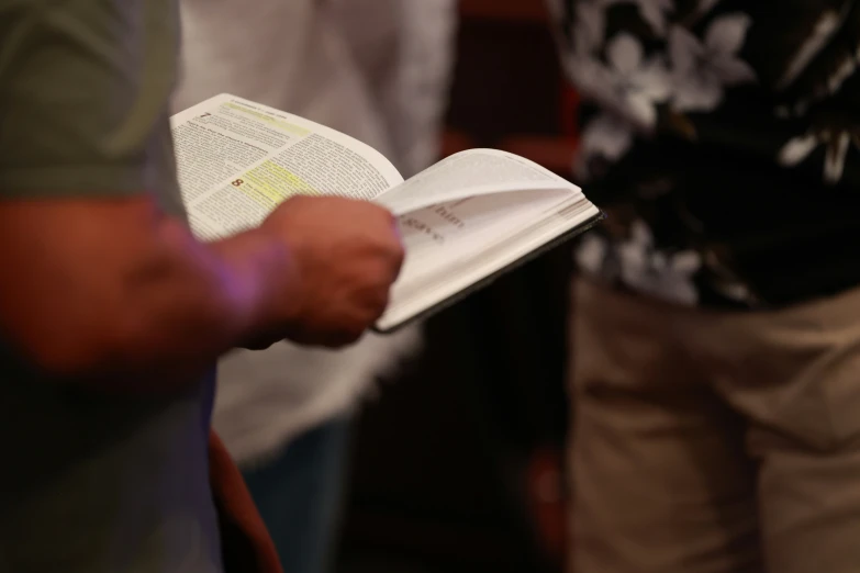 a person holding an open book in their hand