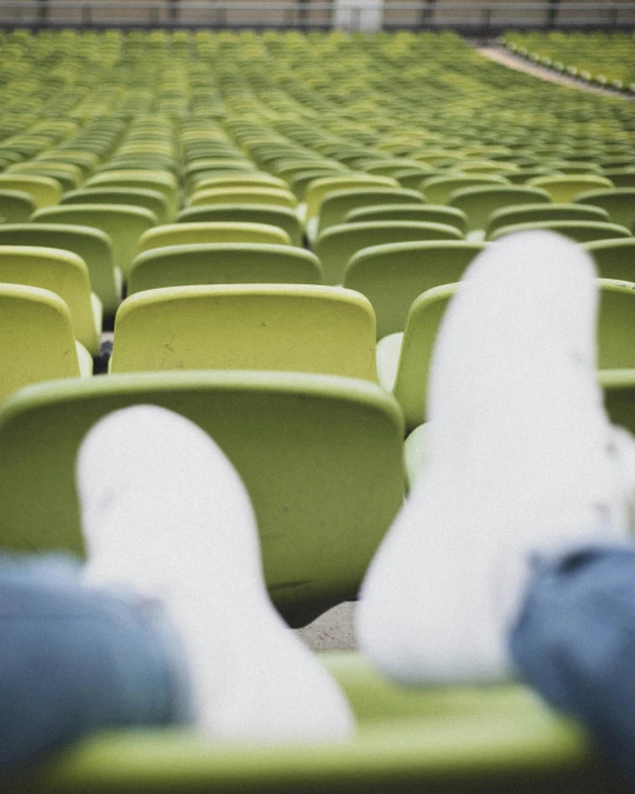 a large row of green chairs in an empty arena