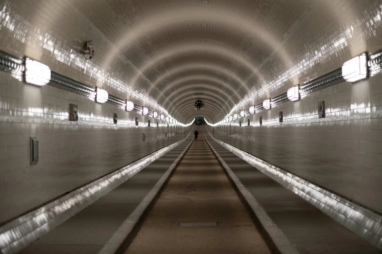 a long tunnel with lights and concrete floor