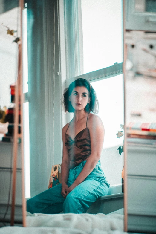 a young woman sits in the corner of a room