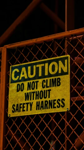 an orange sign with white lettering stating a safety harness
