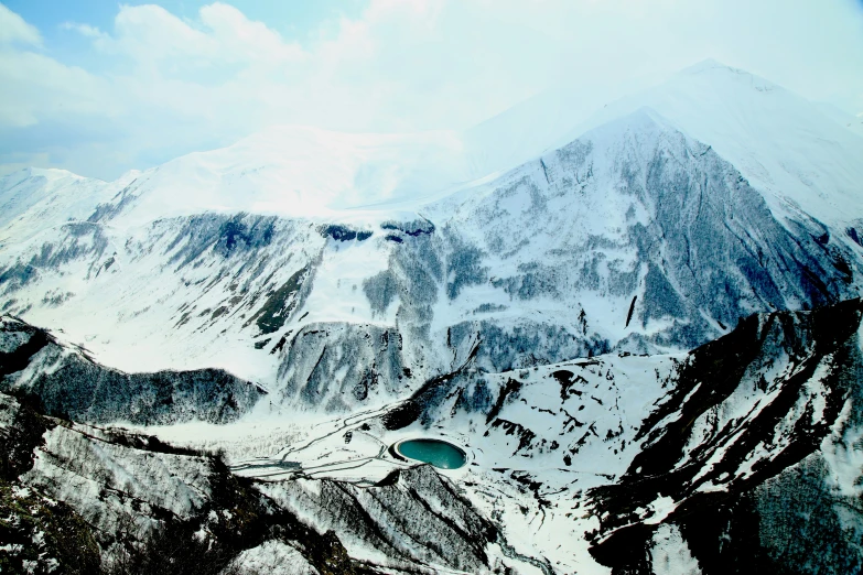 snow covered mountain tops with a body of water below