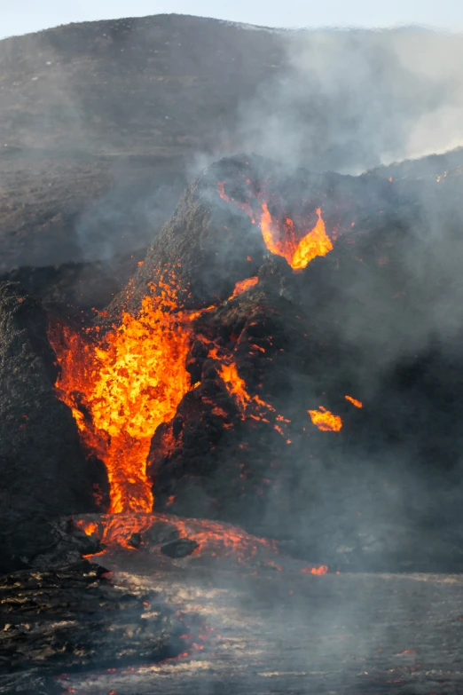 some yellow and black flames are seen coming out of the side of the mountain