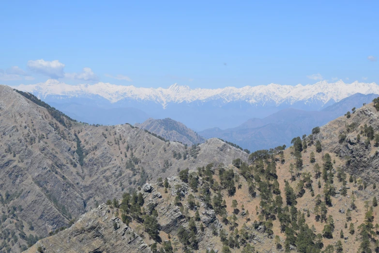 the mountains are covered in snow as seen from a trail