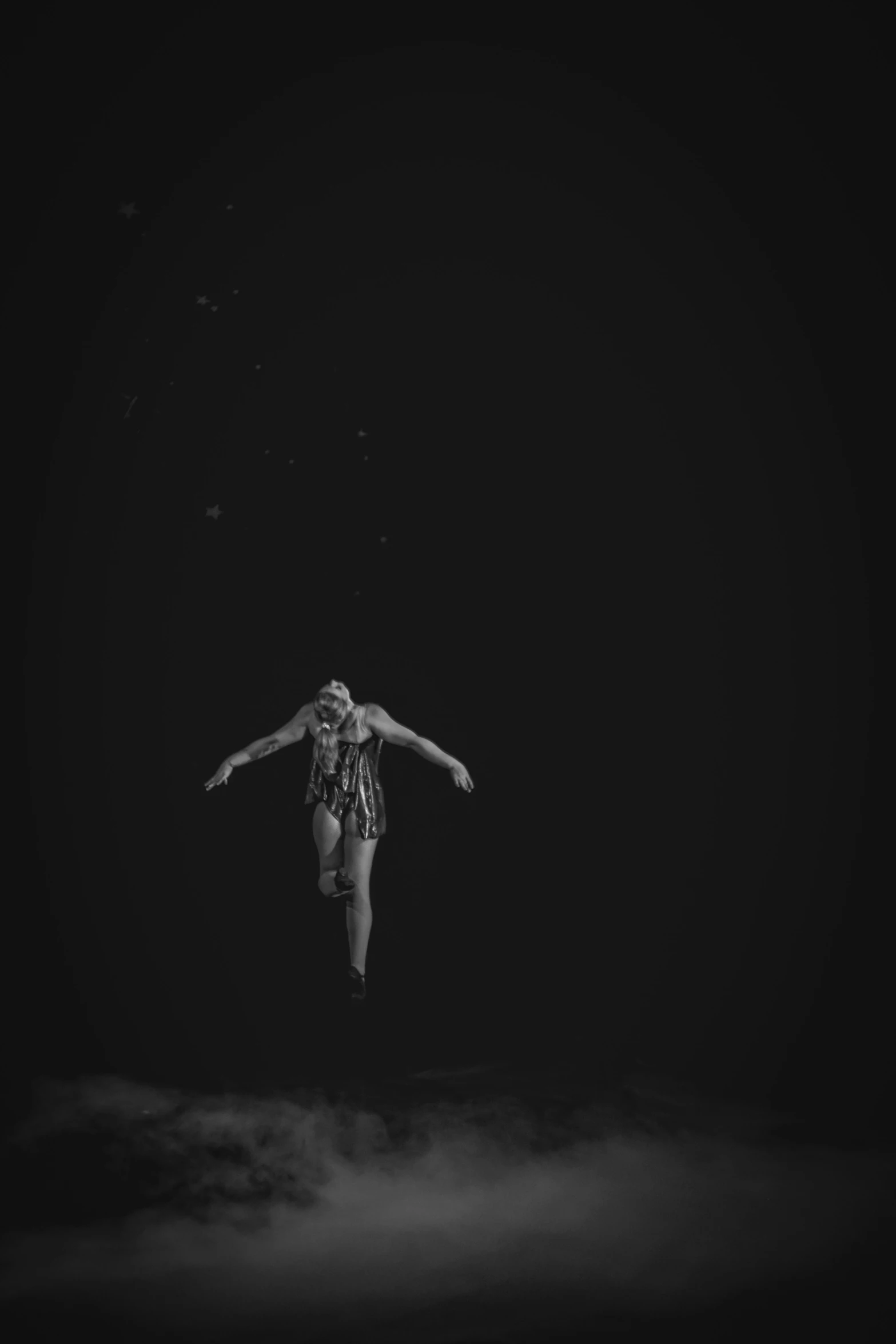a woman flying through the air while standing in front of a dark background