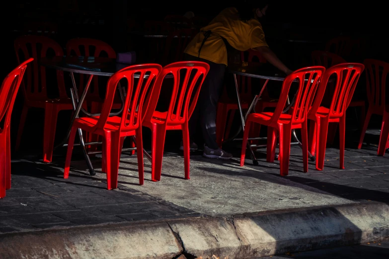 rows of red chairs are set out on the sidewalk