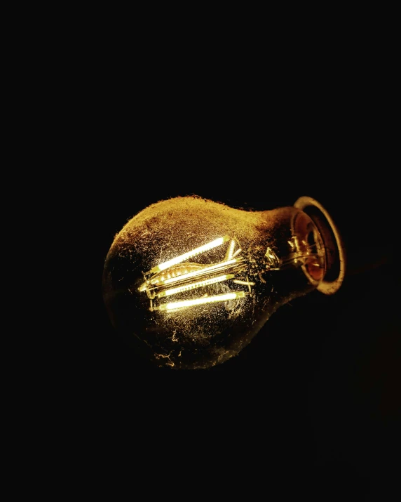 light bulb glowing on a dark black background