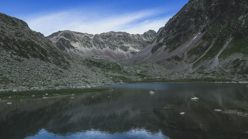 a mountain range sits across the lake from other mountains