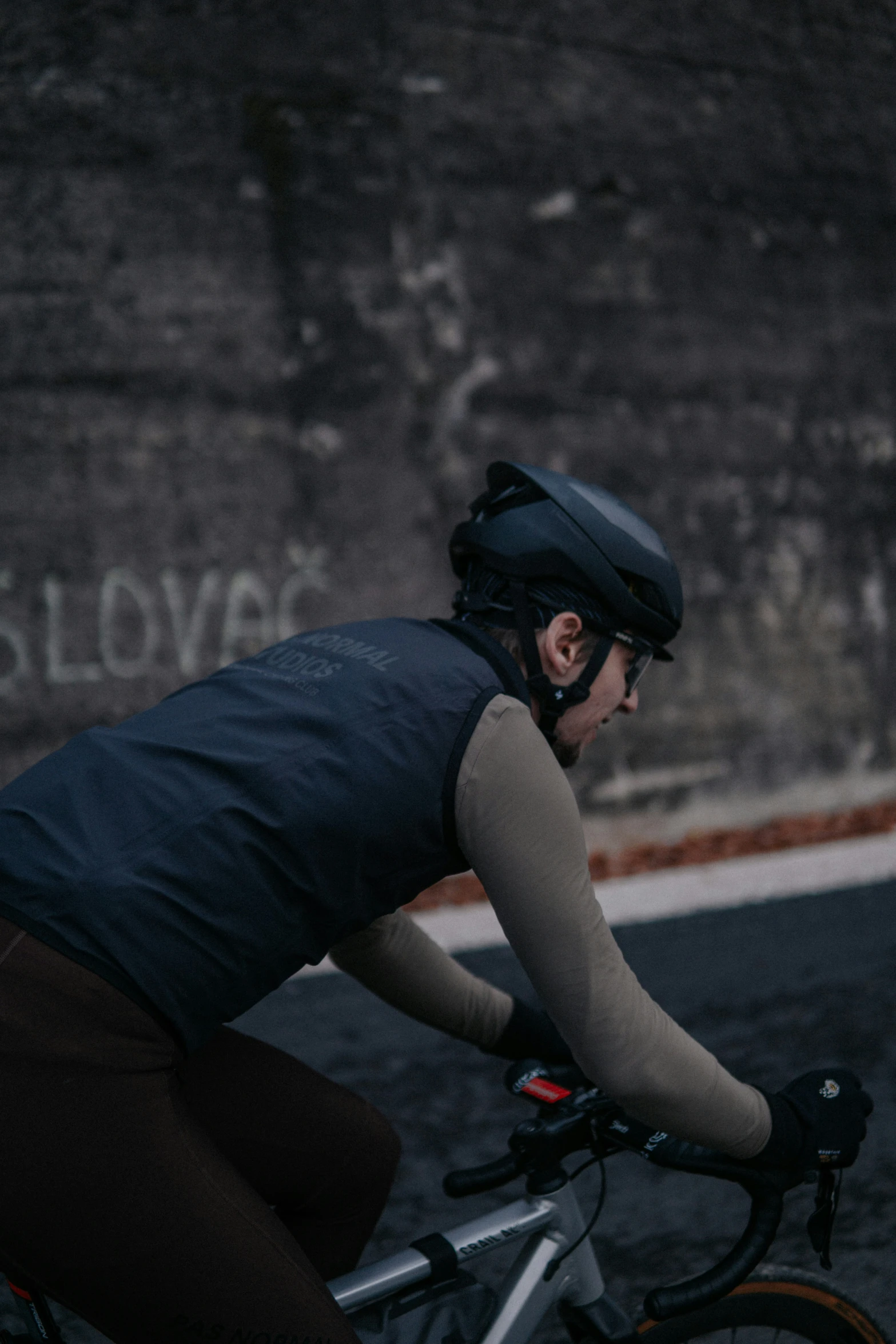 a man riding a bike past a graffiti covered wall