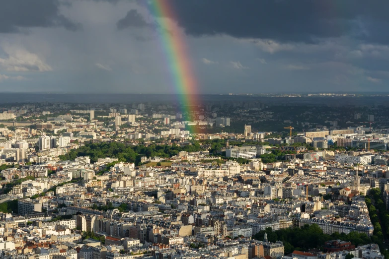 a rainbow over an urban area on a cloudy day