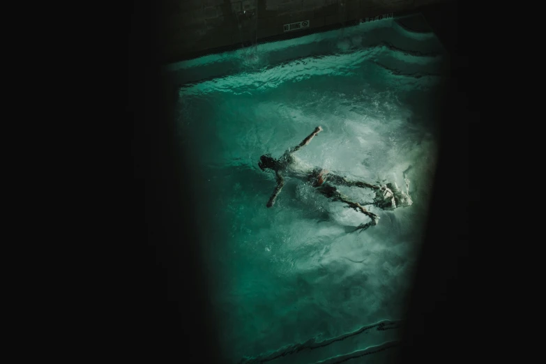 a person in a green tub swimming at night