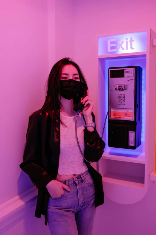 a woman wearing a black face mask next to an empty emergency exit atm machine