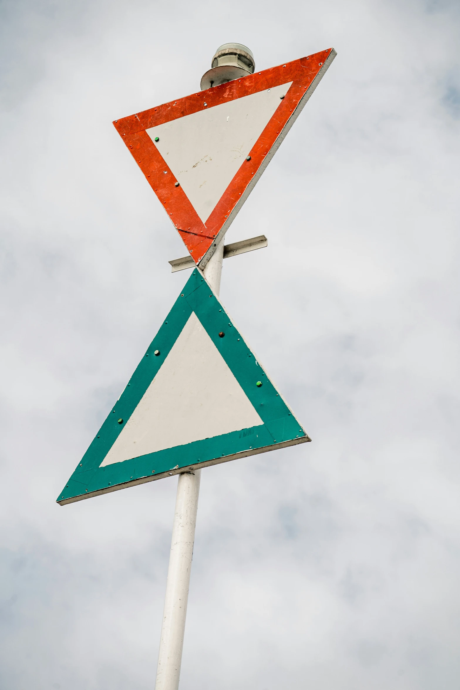 a road sign stands in front of a white cloudy sky