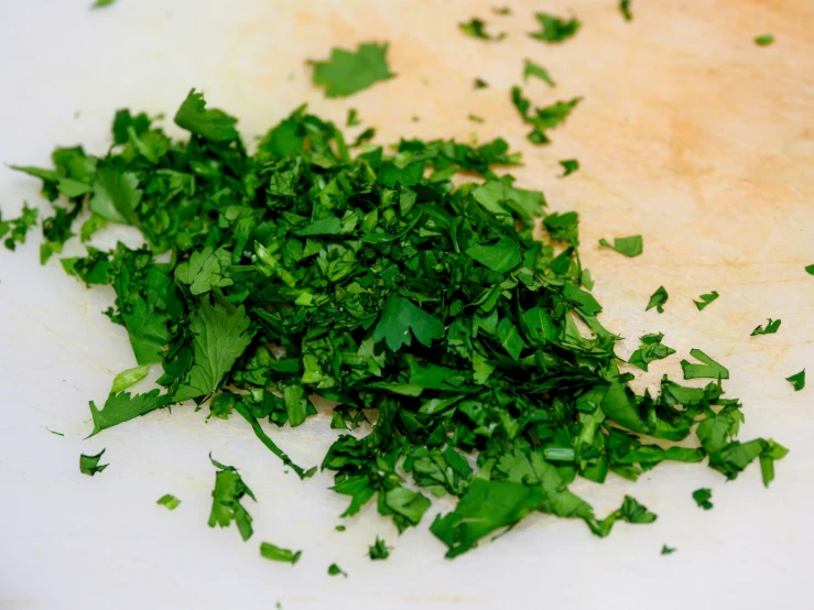 a white  board topped with chopped green vegetables