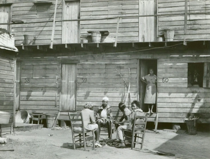 an old black and white po shows people sitting on a chair