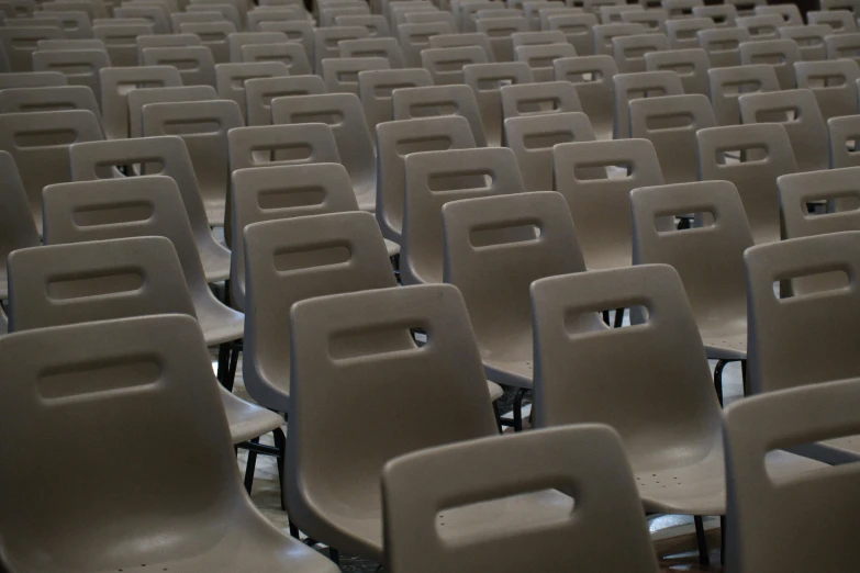 rows of chairs sit empty in an auditorium