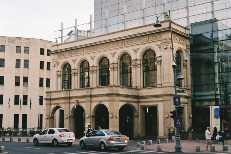 two cars are parked near two large buildings