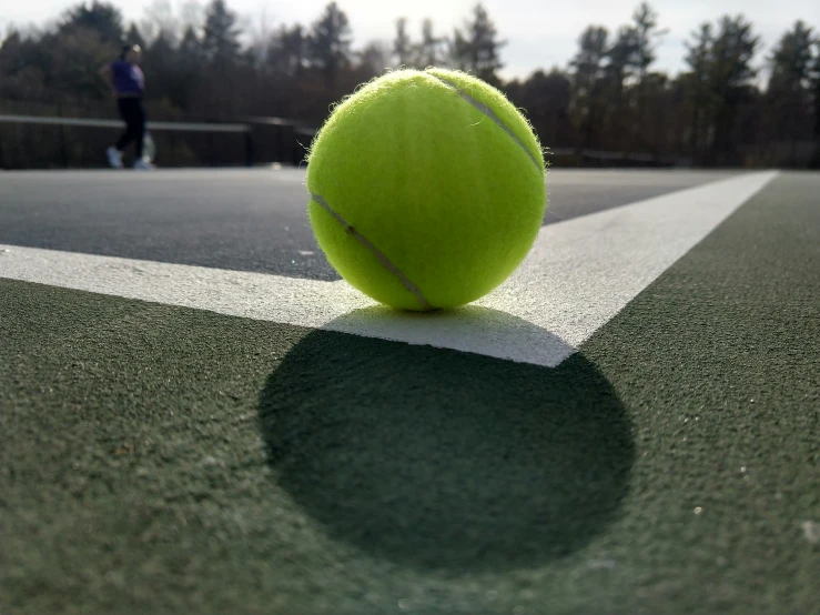 a tennis ball on the ground in front of people