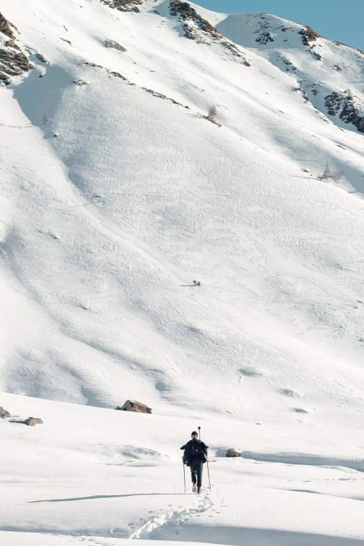 a man walking through a snow covered mountain side