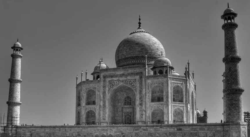 the building has three tall towers on one side and a large dome on the other