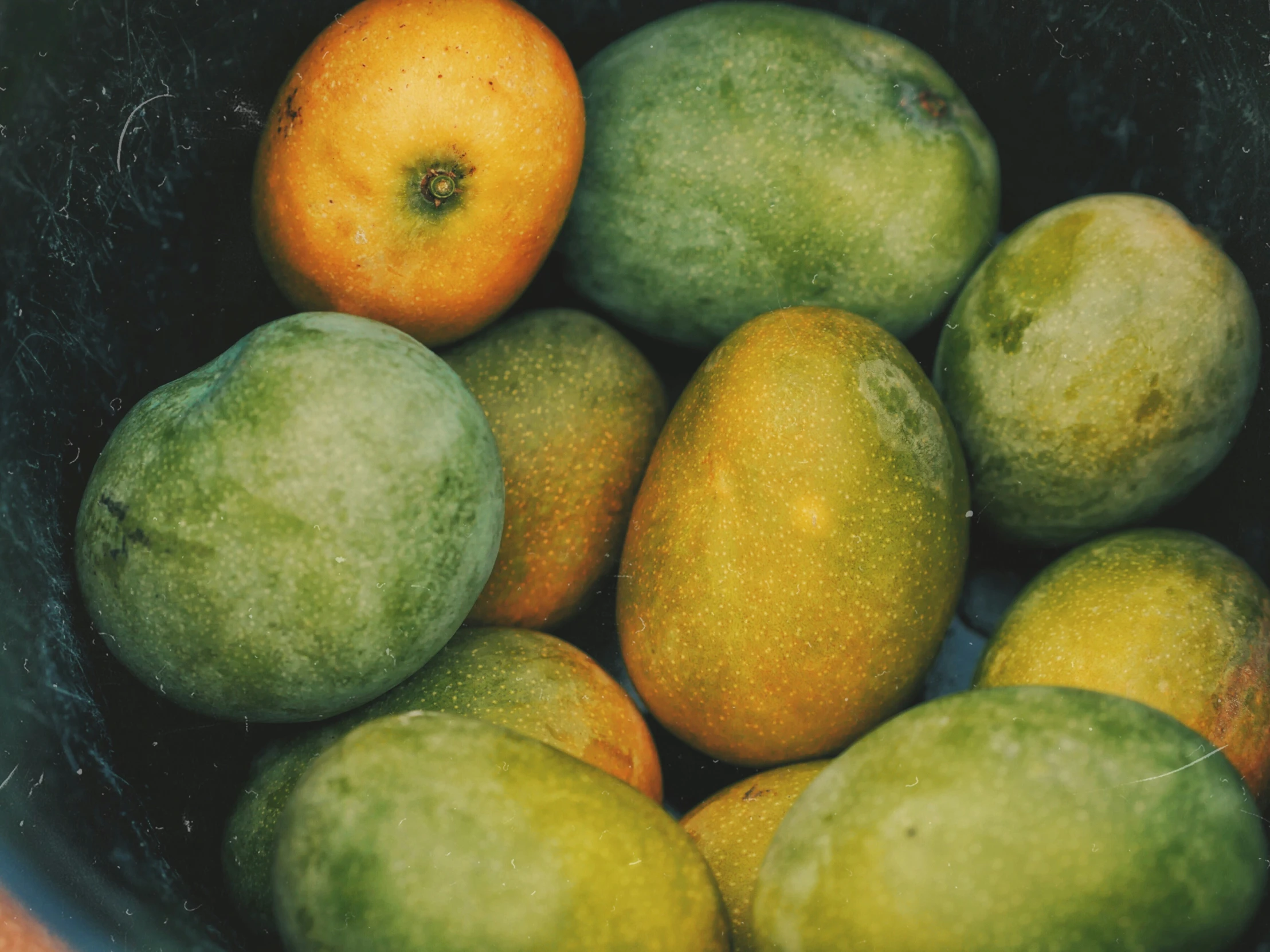 group of green and oranges in a black bowl