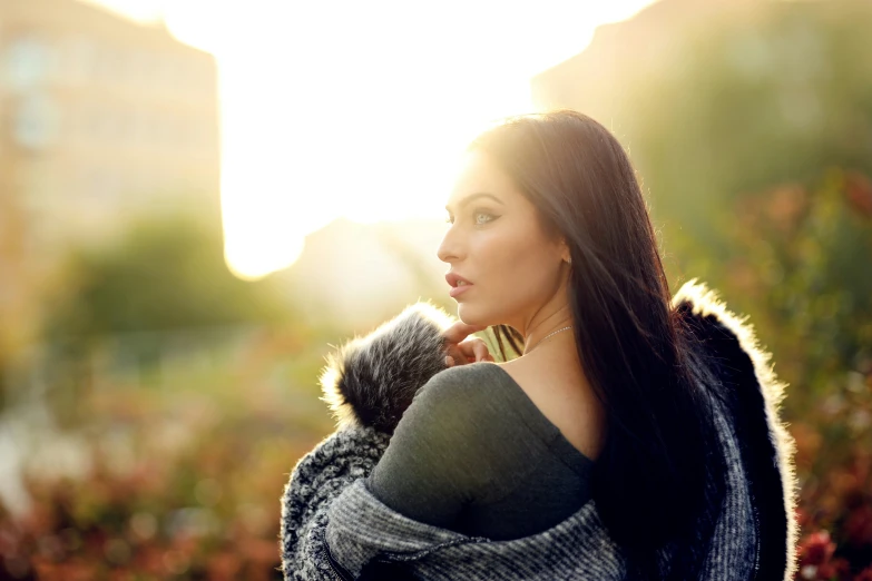 woman with hood up looking at the sun