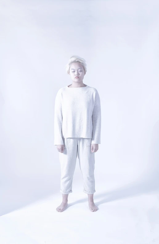 a small child stands alone against a white background