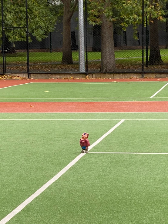 a small child sitting on the tennis court