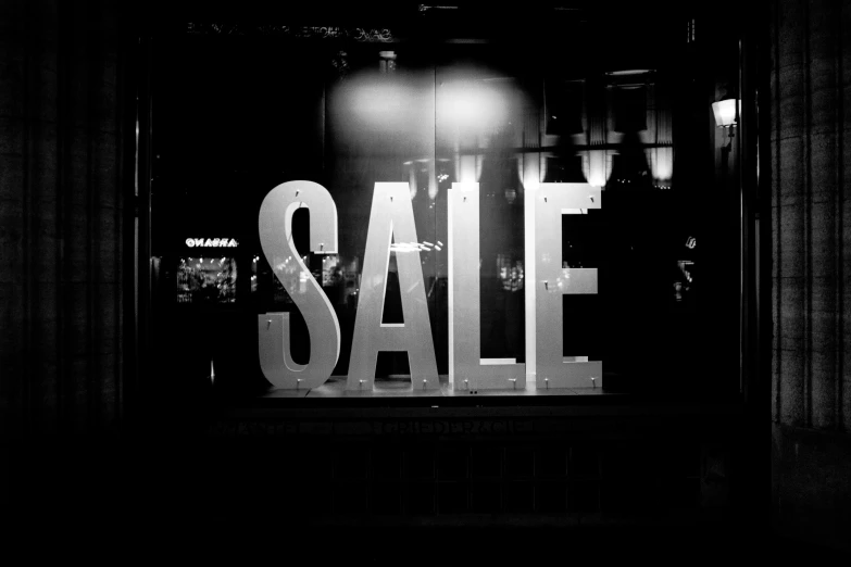 black and white pograph of sale sign on the window