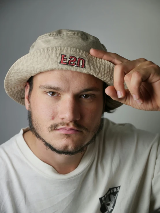 a young man wearing a hat while posing for the camera