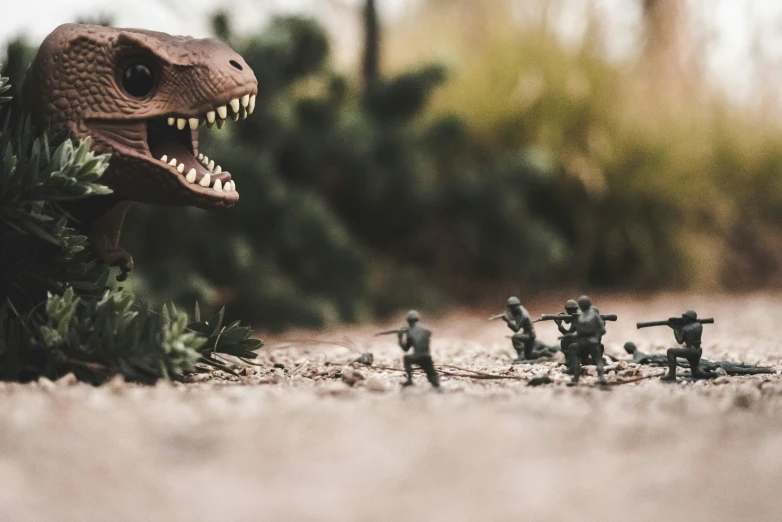 several toy soldiers stand near an enormous dinosaur